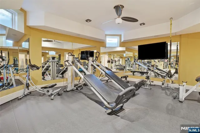 a living room with gym equipment and a flat screen tv