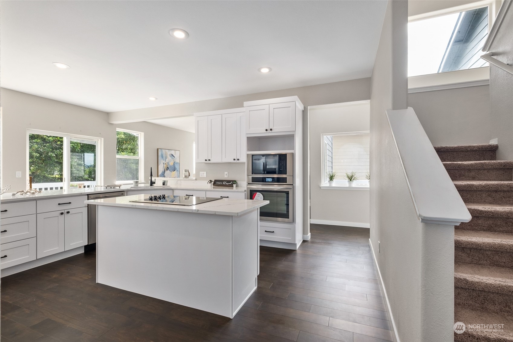 1203 South 35th Street Renton, WA 98055 - Photo 23 of 38 a kitchen with stainless steel appliances kitchen island wooden floors and white cabinets