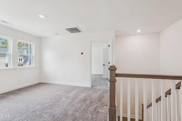 a kitchen with stainless steel appliances a stove top oven a sink a refrigerator white cabinets and wooden floor