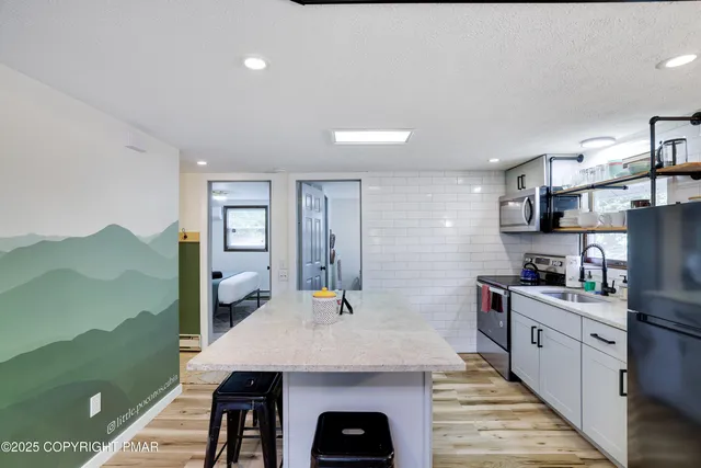 a bathroom with a toilet sink vanity granite and a shower
