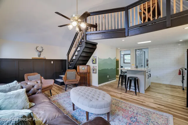 a living room with furniture a rug a lamp and a window