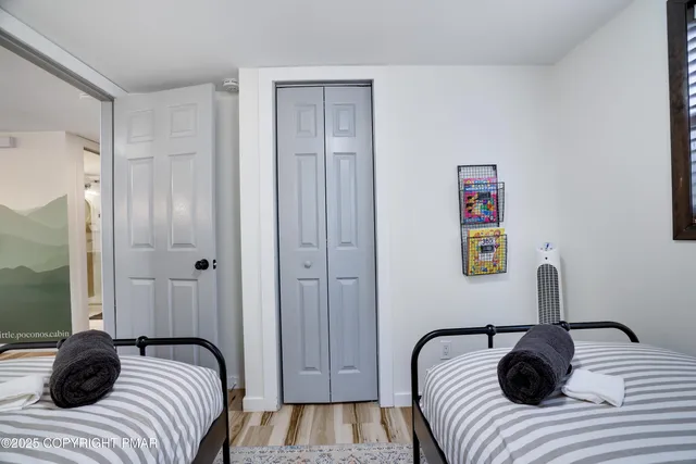 a bedroom with a bed a flat screen tv and a window