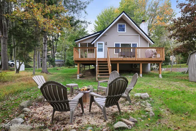 a view of house with backyard and sitting area