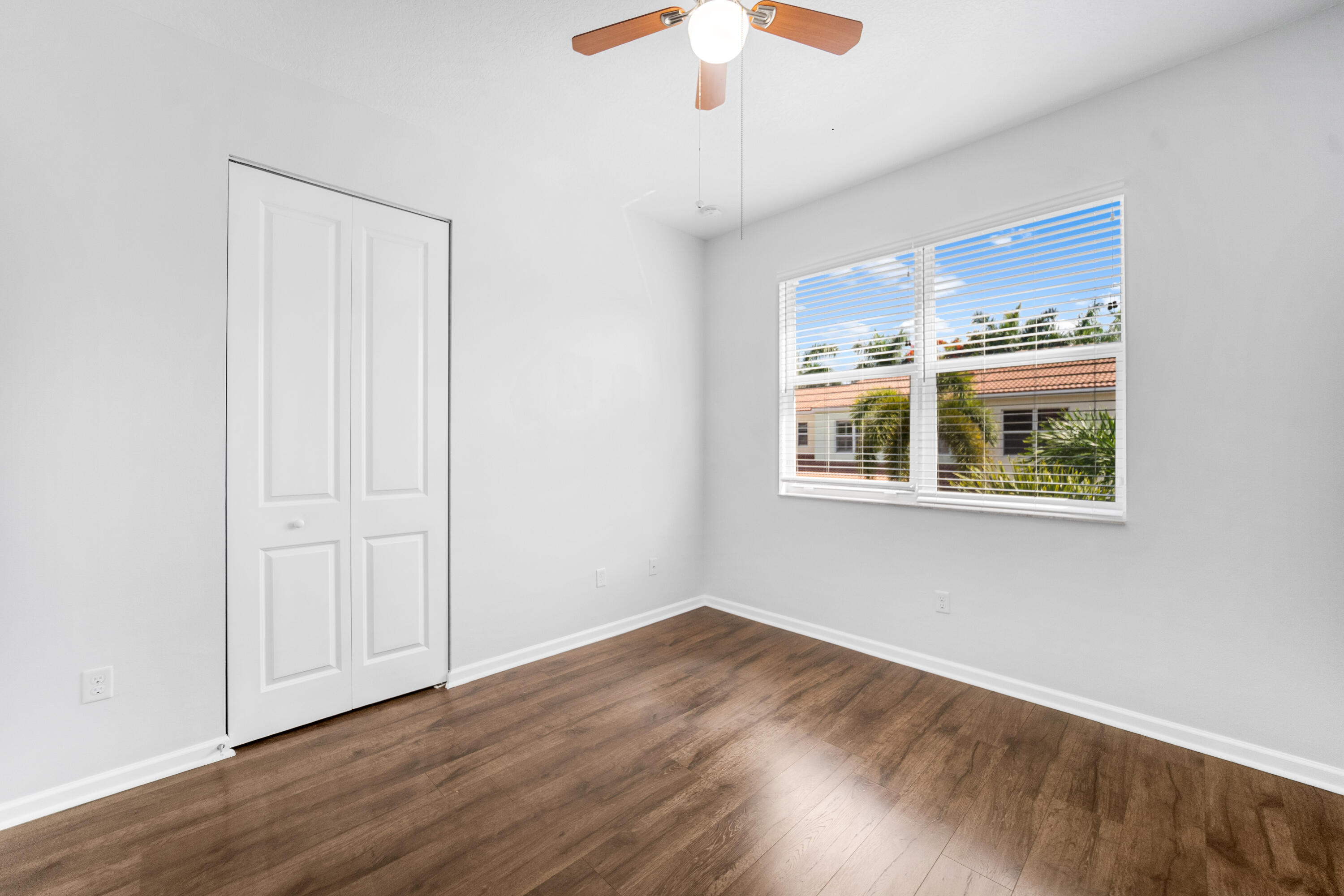 1430 Northwest 48th Lane Boca Raton, FL 33431 - Photo 18 of 54 a view of an empty room with wooden floor and a window
