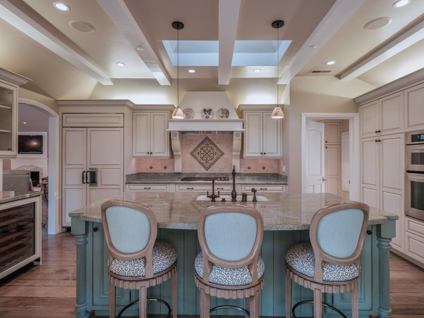 1471 Riata Road Pebble Beach, CA 93953 - Photo 12 of 29 a kitchen with granite countertop a dining table chairs stove and sink