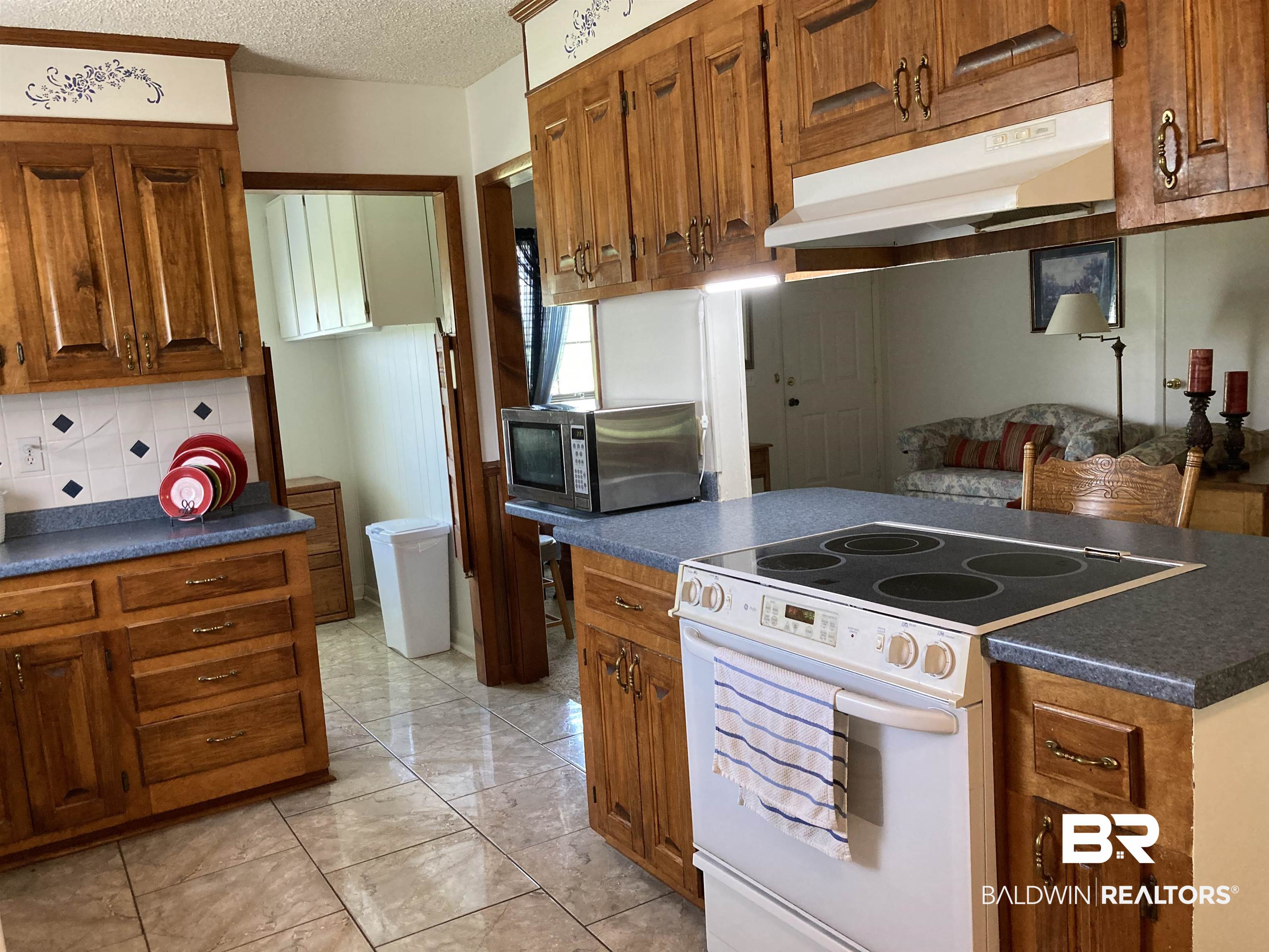 6151 Meadows Road Walnut Hill, FL 32568 - Photo 13 of 29 Kitchen with backsplash, light tile patterned floors, a textured ceiling, and white electric range