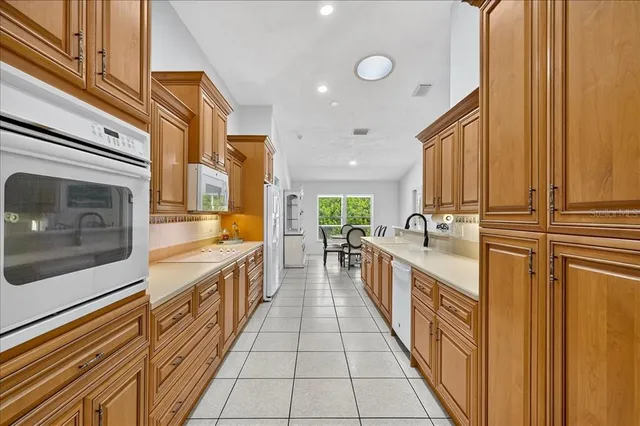 a large kitchen with stainless steel appliances a large counter top a stove and a sink