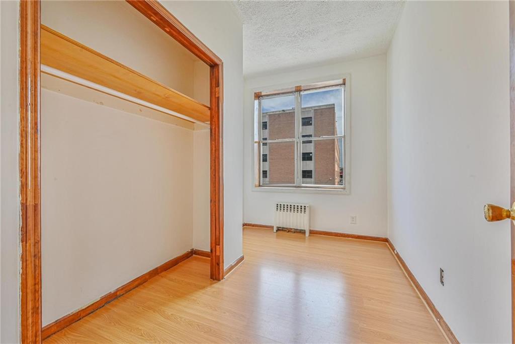 1270 68th Street Brooklyn, NY 11219 - Photo 12 of 20 a view of an empty room with wooden floor and a window