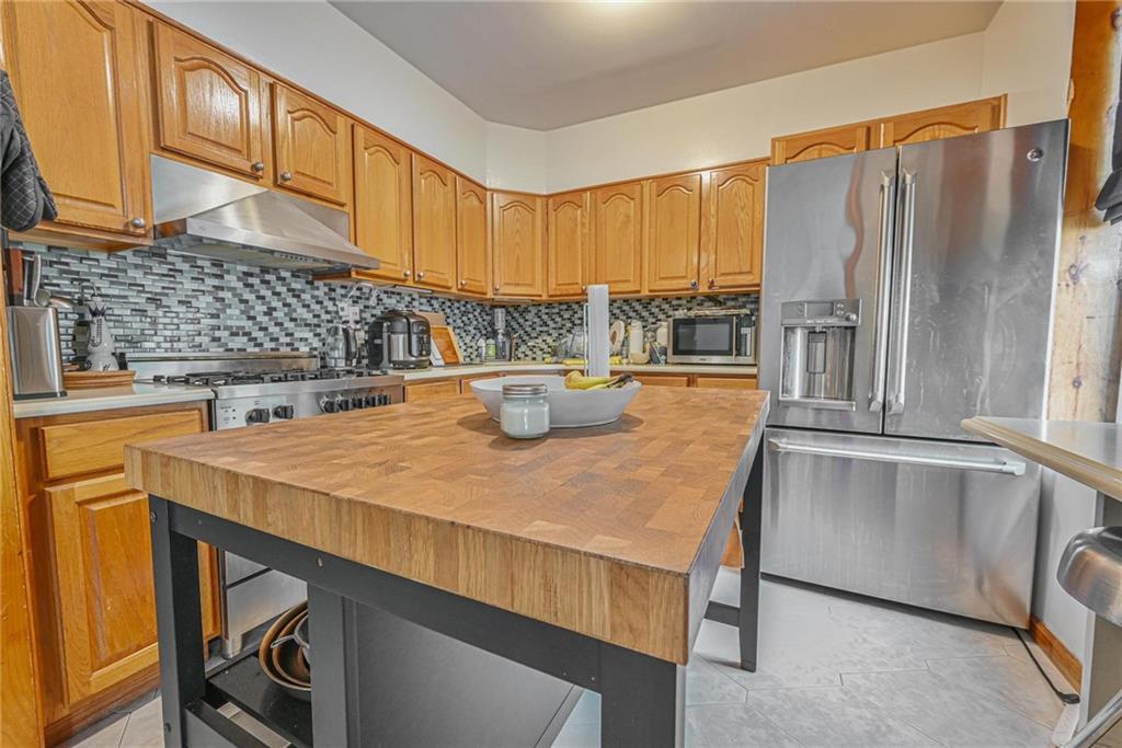 1270 68th Street Brooklyn, NY 11219 - Photo 4 of 20 a kitchen with a sink a refrigerator and cabinets
