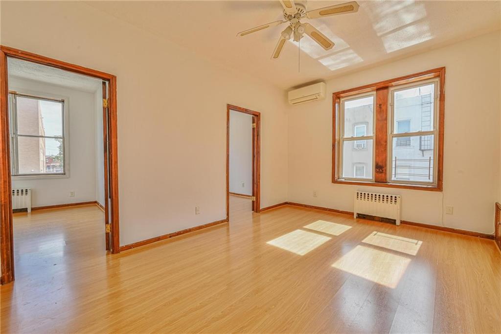 1270 68th Street Brooklyn, NY 11219 - Photo 9 of 20 an empty room with wooden floor fan and windows