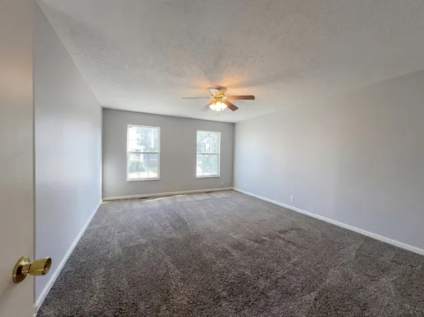 an empty room with windows and closet