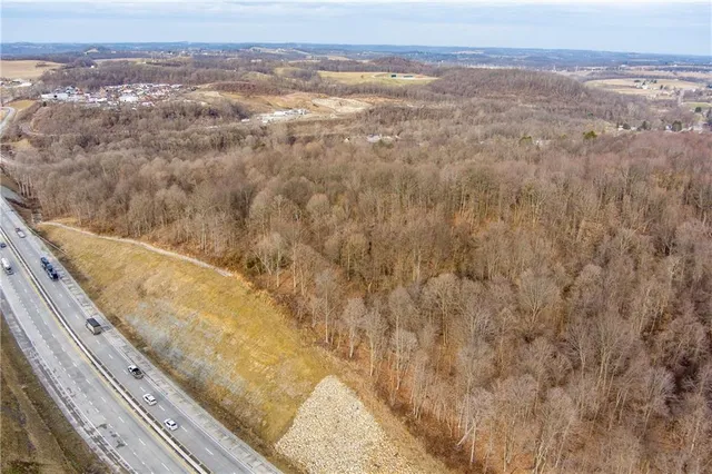 an aerial view of residential houses with outdoor space and trees