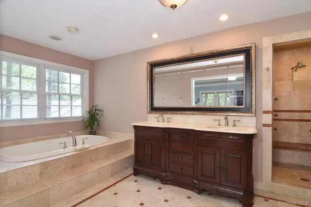 a bedroom with a bed and dresser with wooden floor