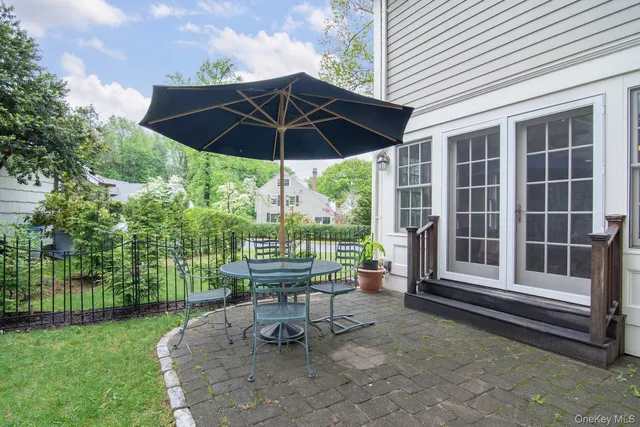 a view of a patio with table and chairs under an umbrella
