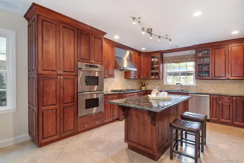 a kitchen with granite countertop stainless steel appliances a stove sink and microwave