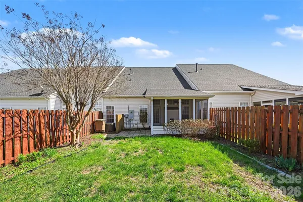 a view of a house with a big yard plants and large tree