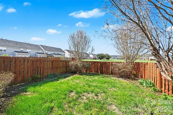 a view of a backyard with potted plants and wooden fence