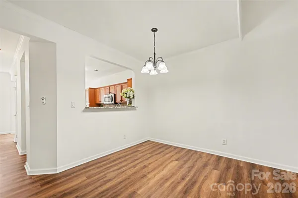 a view of a room with wooden floor and chandelier