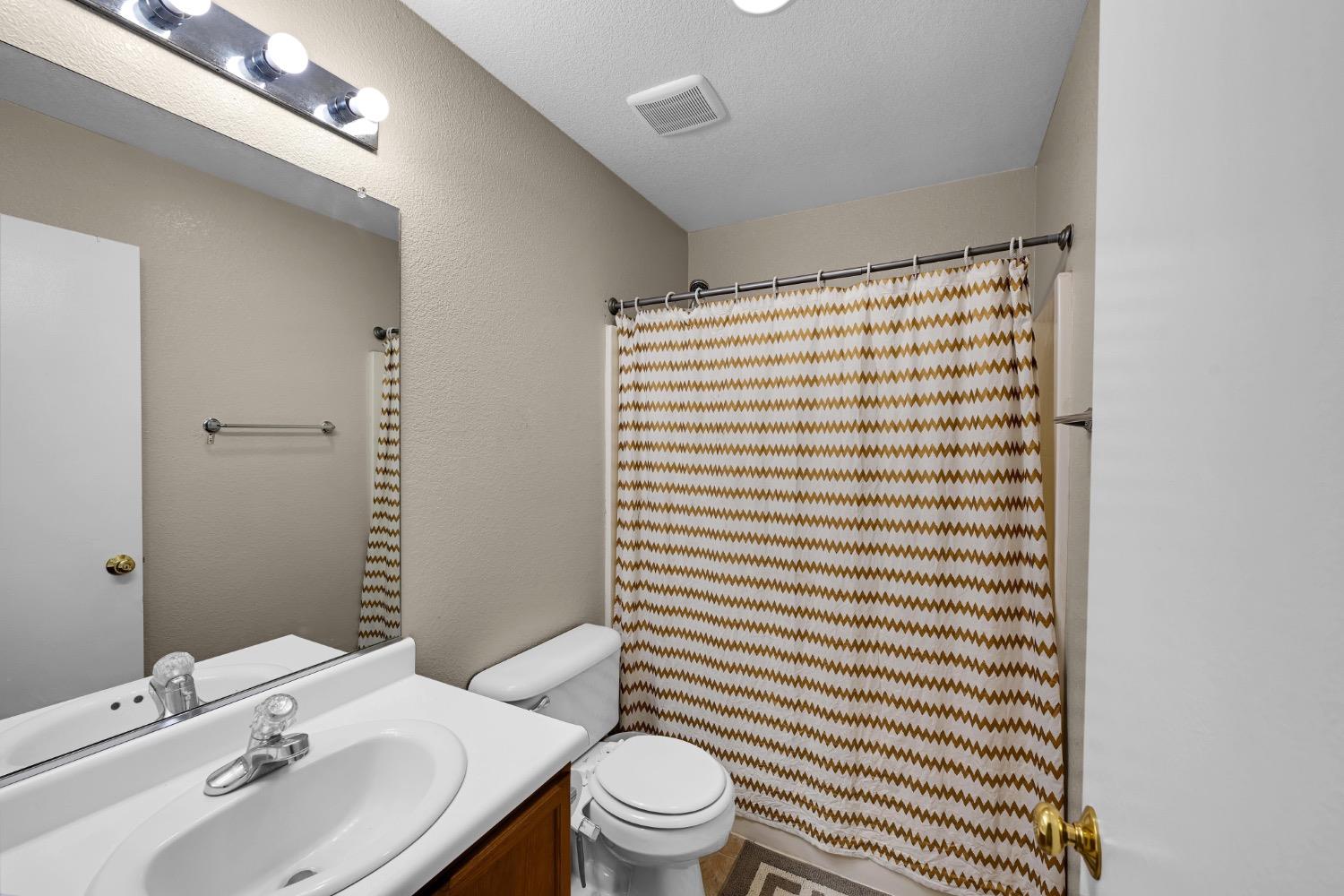 4627 Excelsior Road Mather, CA 95655 - Photo 19 of 33 a bathroom with a sink a toilet and shower curtain