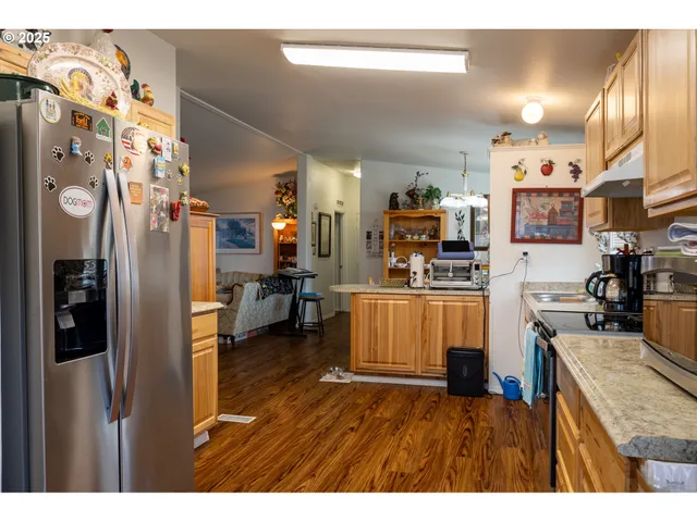 a kitchen that has a lot of cabinets a sink and a wooden floor