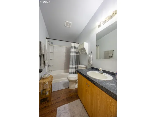 a bathroom with a granite countertop sink mirror toilet and bathtub