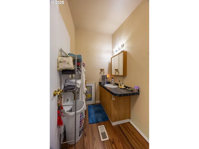 a view of a living room with a sink and wooden floor