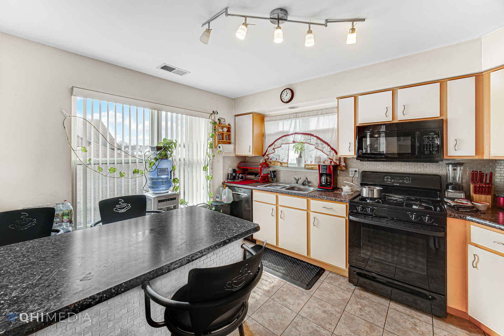 3415 Huntley Terrace, Unit D Crete, IL 60417 - Photo 11 of 22 a kitchen with stainless steel appliances granite countertop a stove top oven a sink dishwasher a dining table and chairs with wooden floor