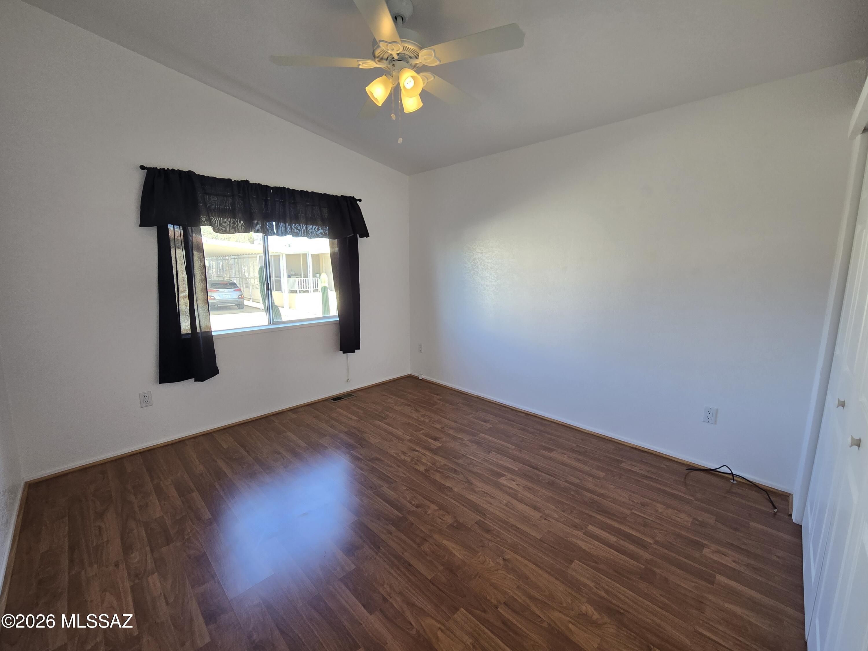 8401 South Kolb Road, Unit 61 Tucson, AZ 85756 - Photo 10 of 23 an empty room with wooden floor and windows