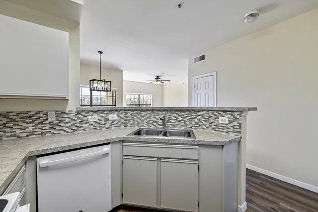a kitchen with a sink and a wooden floor