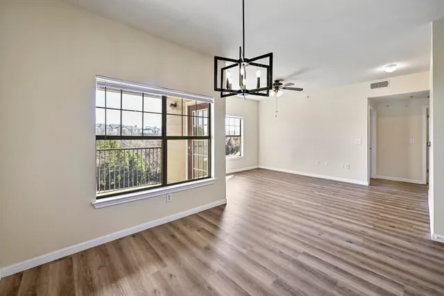 a view of a room with wooden floor windows and a chandelier