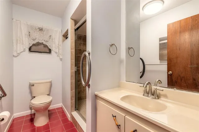 an empty room with a chandelier fan and windows