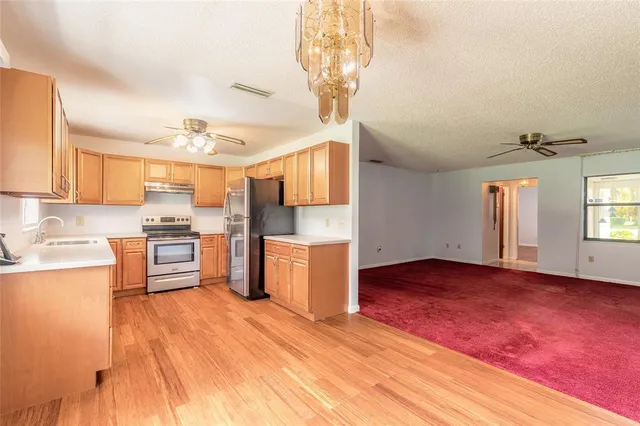 an empty room with windows and ceiling fan
