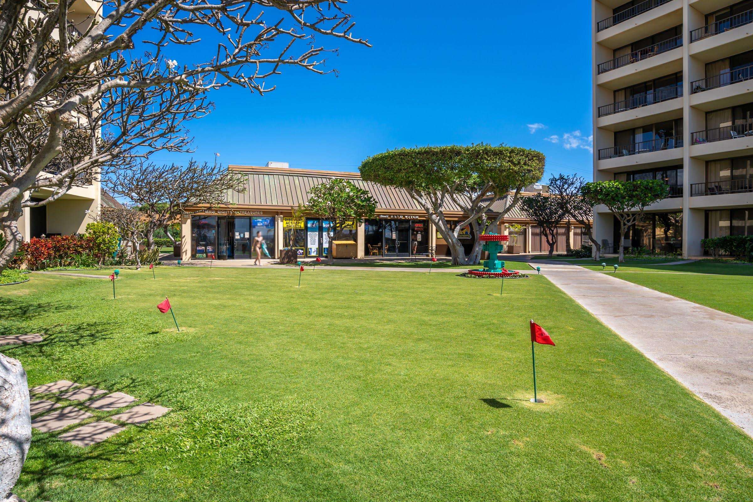 145 North Kihei Road, Unit 103 Kihei, HI 96753 - Photo 42 of 49 a front view of a building with a garden and trees