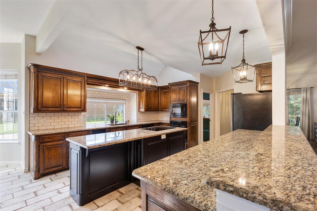 609 Seville Road Denton, TX 76205 - Photo 3 of 40 Gourmet Chef's Kitchen with abundant granite counters, cabinets, island and light filled.