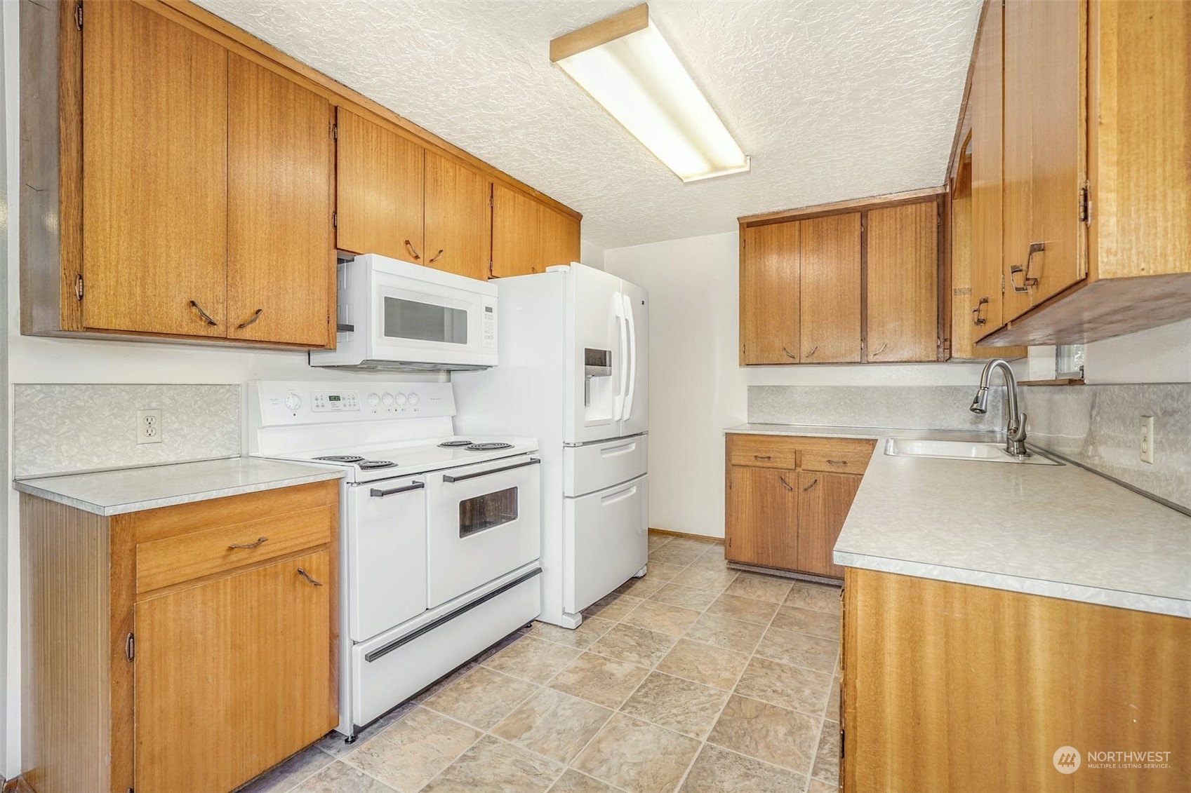 4151 23rd Avenue Southwest Seattle, WA 98106 - Photo 13 of 36 a kitchen with a sink stove and cabinets
