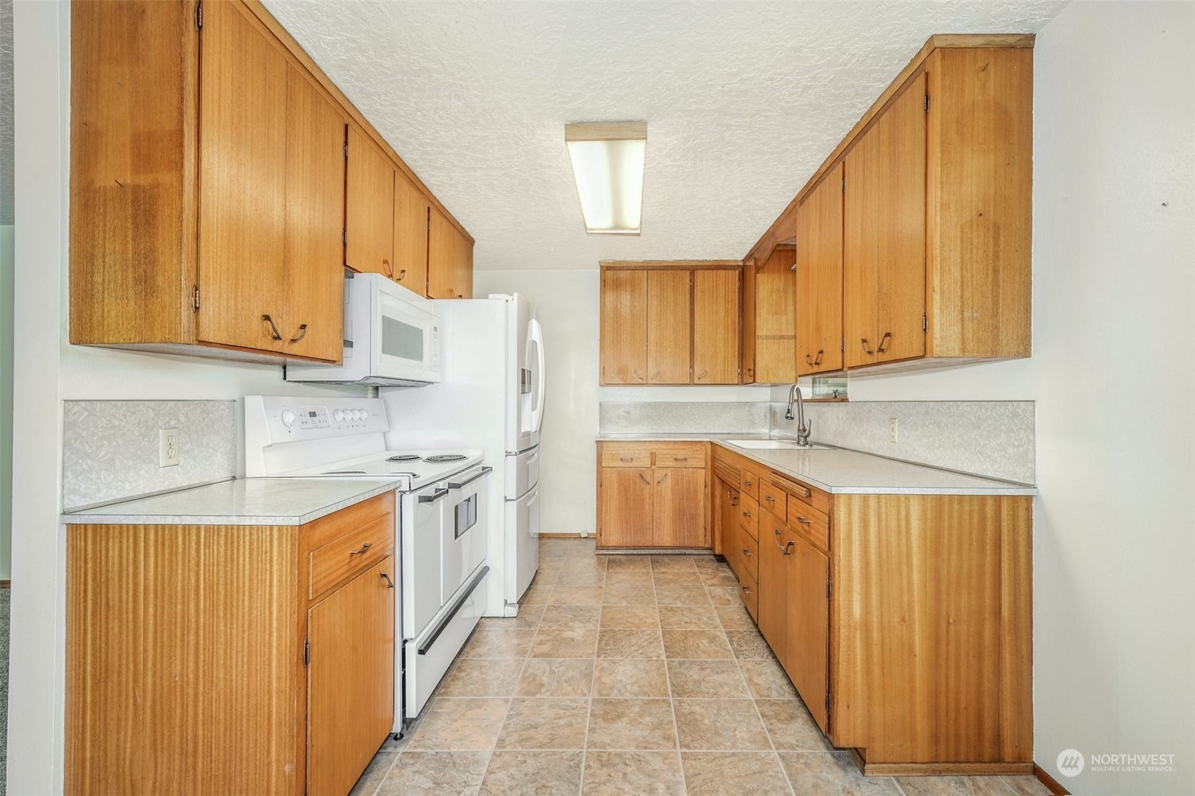 4151 23rd Avenue Southwest Seattle, WA 98106 - Photo 15 of 36 a kitchen with stainless steel appliances granite countertop a sink and cabinets