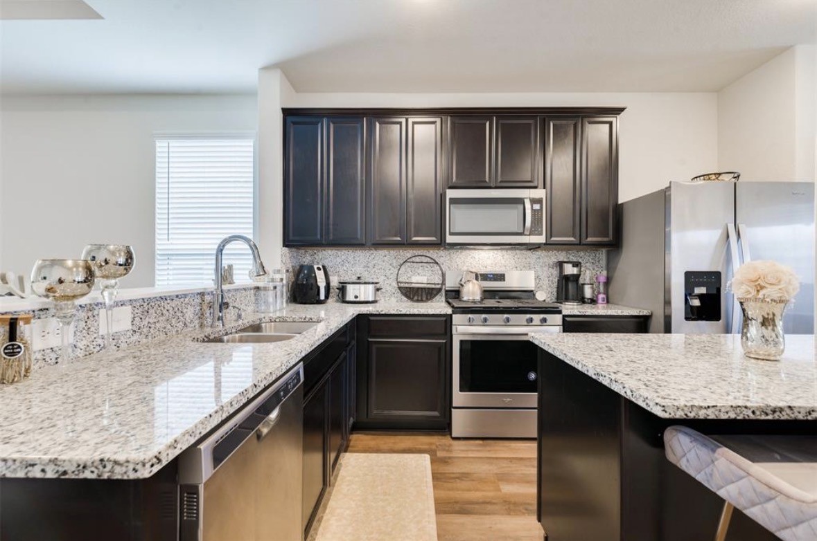 25535 Pitchfork Ranch Place Katy, TX 77493 - Photo 23 of 25 a kitchen with kitchen island granite countertop a sink stove and refrigerator