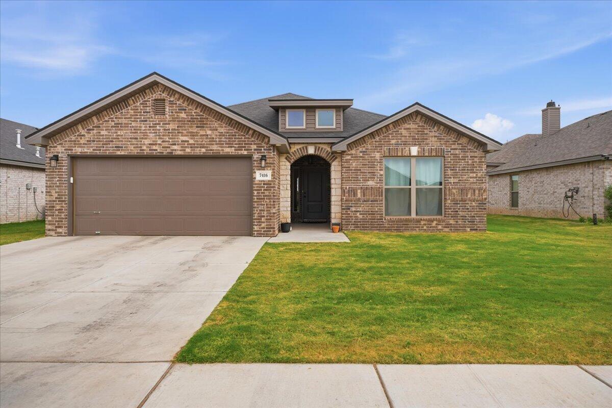 7416 30th Street Lubbock, TX 79407 - Photo 1 of 31 a front view of a house with a garden and yard
