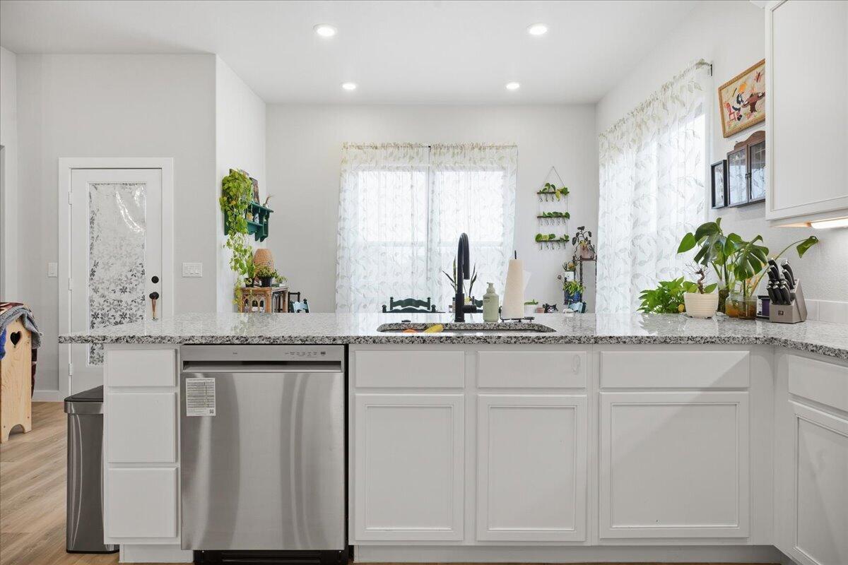 7416 30th Street Lubbock, TX 79407 - Photo 12 of 31 a sink with white cabinets and potted plant