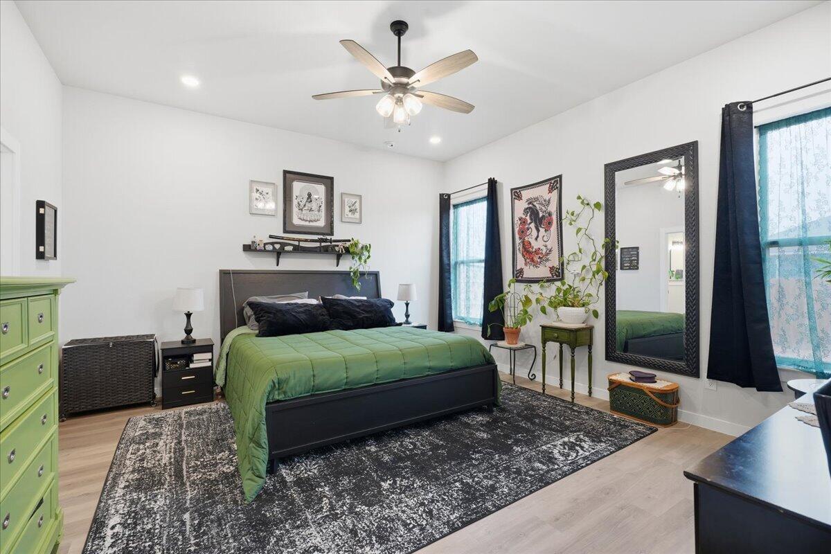 7416 30th Street Lubbock, TX 79407 - Photo 15 of 31 a bedroom with a bed a chandelier and dresser