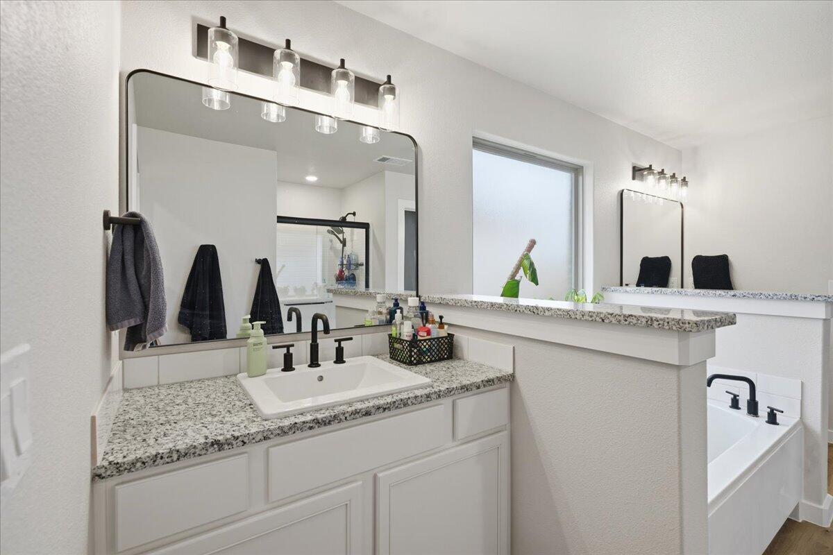 7416 30th Street Lubbock, TX 79407 - Photo 20 of 31 a bathroom with double vanity sinks and a mirror