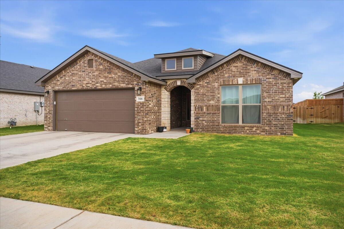 7416 30th Street Lubbock, TX 79407 - Photo 2 of 31 a front view of a house with a yard and garage