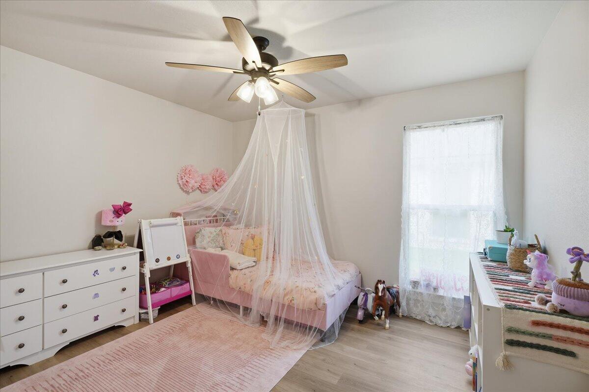 7416 30th Street Lubbock, TX 79407 - Photo 22 of 31 a bedroom with a bed and a chandelier