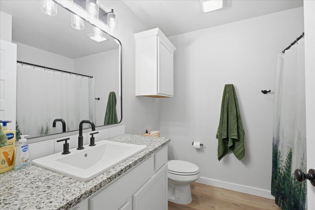 7416 30th Street Lubbock, TX 79407 - Photo 26 of 31 a bathroom with a granite countertop sink and a mirror