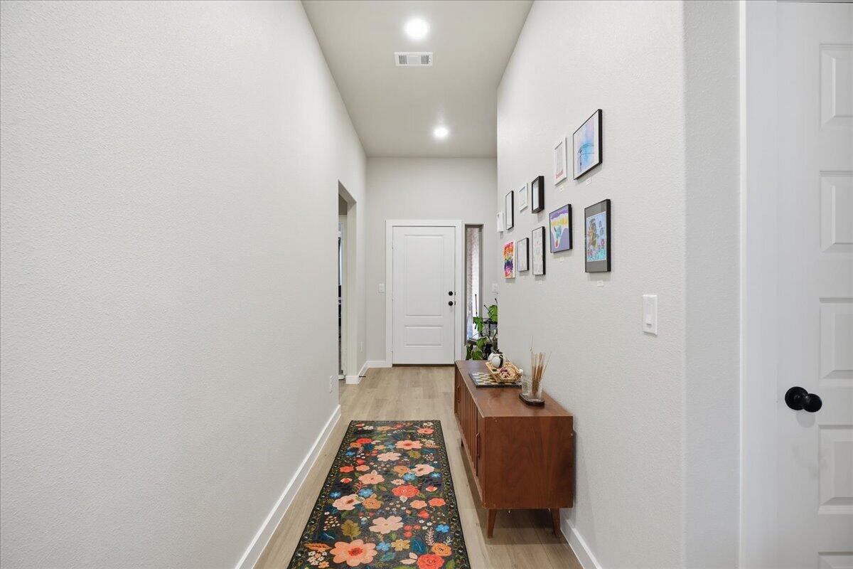 7416 30th Street Lubbock, TX 79407 - Photo 5 of 31 a hallway with front door wooden floor and a rug