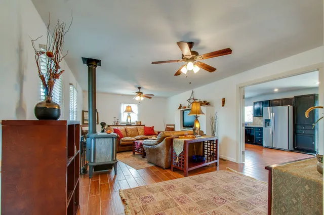a living room with furniture kitchen view and a chandelier