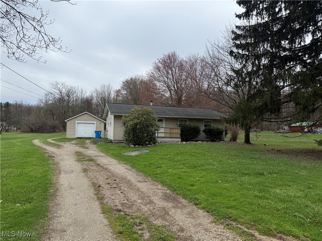 5678 Laskey Road Rome, OH 44085 - Photo 2 of 3 View of front of home with a front lawn, driveway, a detached garage, and an outdoor structure