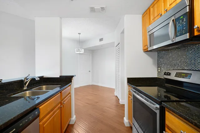 a kitchen with granite countertop a stove and a sink