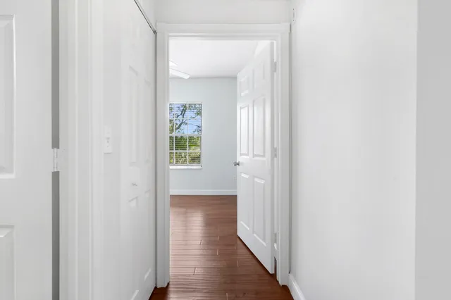 a view of a hallway with wooden floor