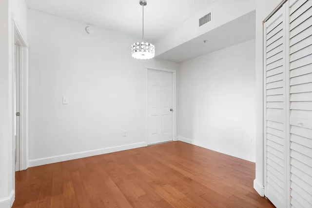 a view of a room with wooden floor and chandelier